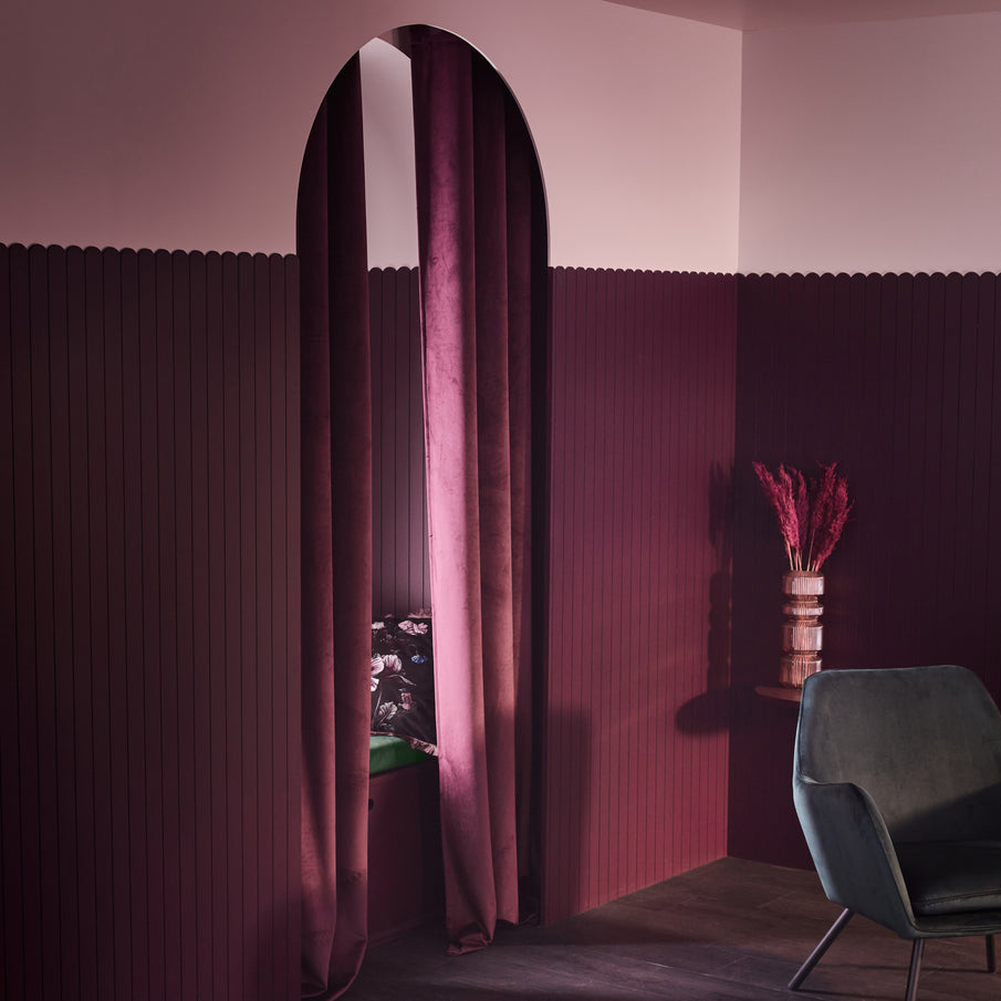 Mur violet et rose avec une arche et des rideaux en velours