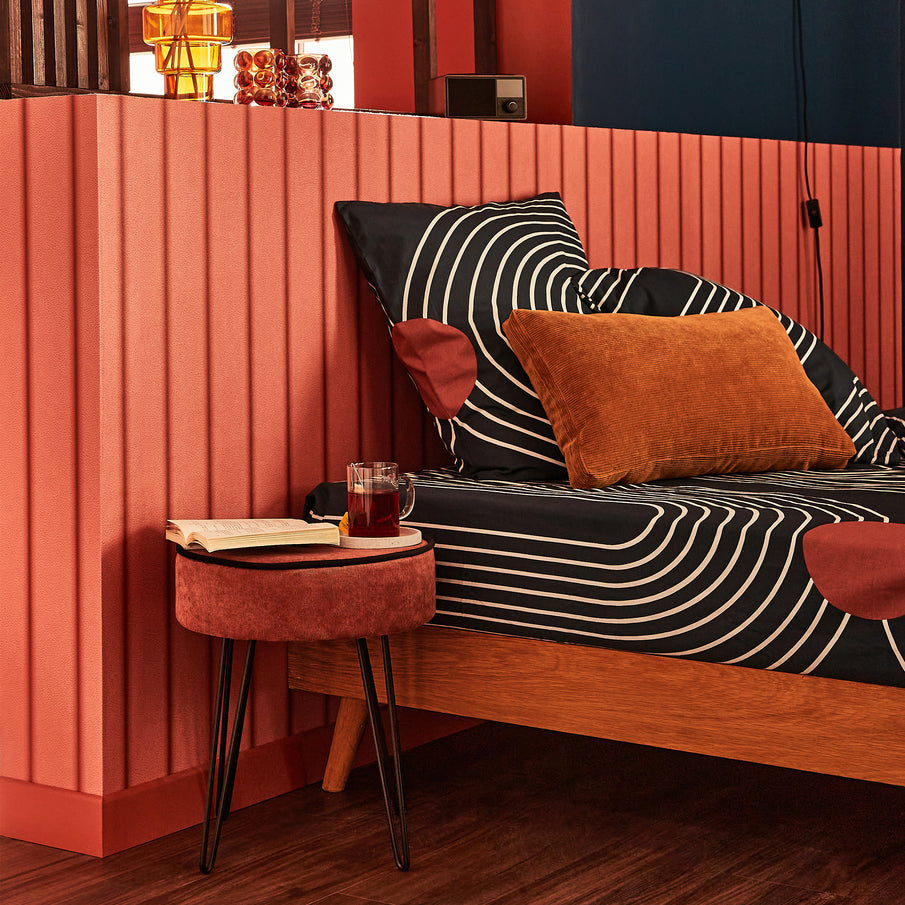 Chambre couleur rouille avec linge de lit bleu à motif blanc 