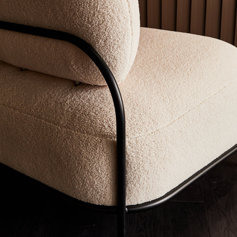 Zoom sur la bouclette d'un fauteuil blanc aux formes arrondies
