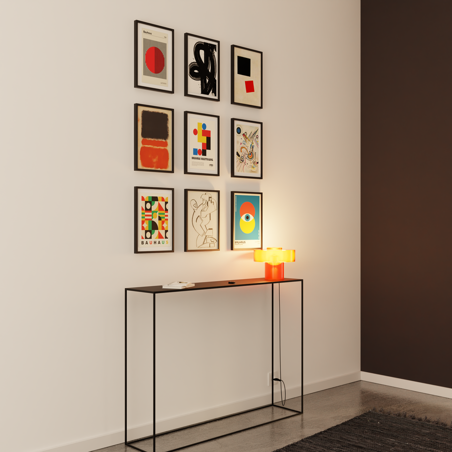 Cadres d'art moderne en alignement au-dessus d'une console noire  