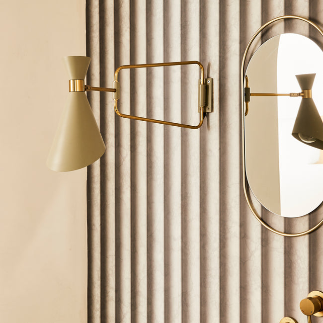 Applique murale et miroir ovale fixés au mur recouvert de papier peint imitation colonnes de marbre