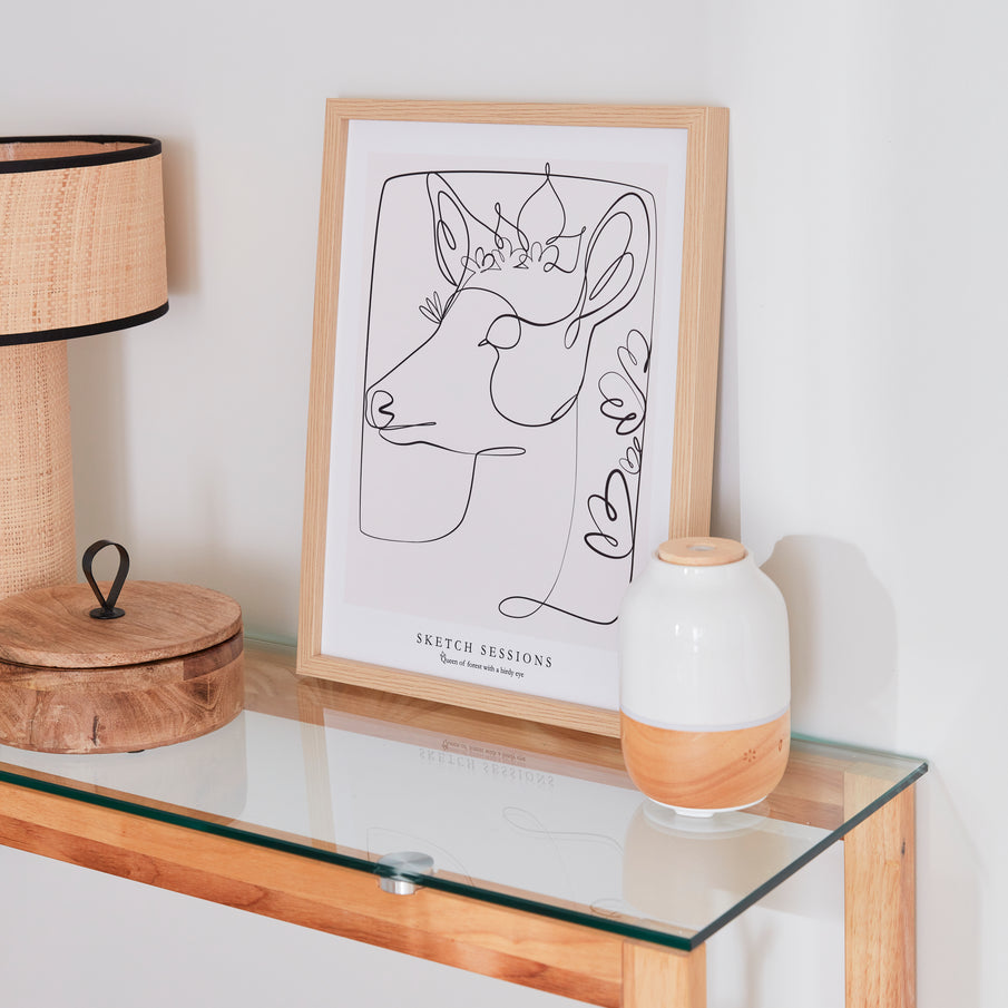 Tableau dessin de biche en line art posé sur une console au plateau en verre