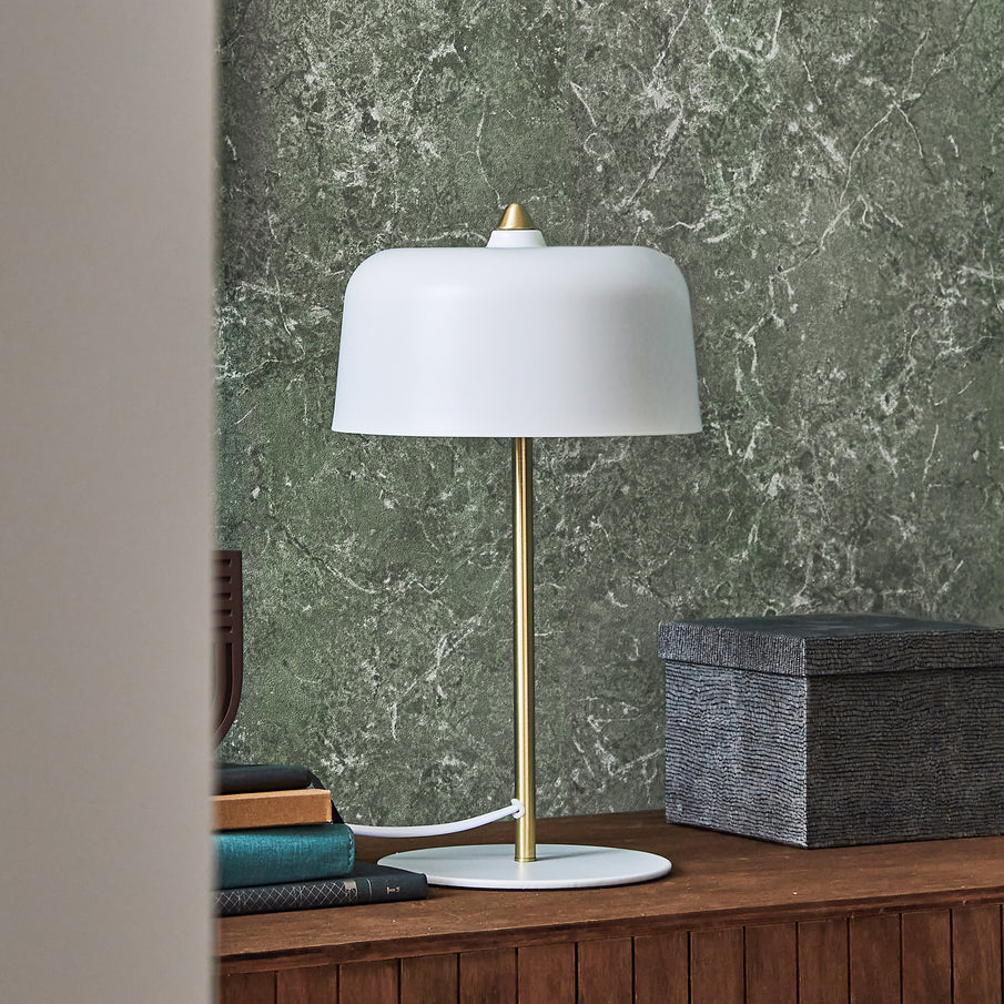 Lampe champignon blanche avec pied doré sur buffet devant papier peint vert effet marbre