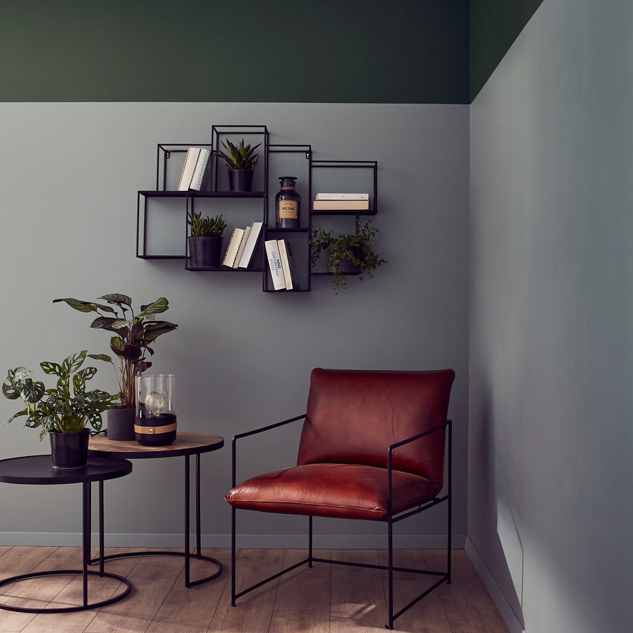 Coin lecture fauteuil en cuir cognac, murs peints en gris et vert foncé