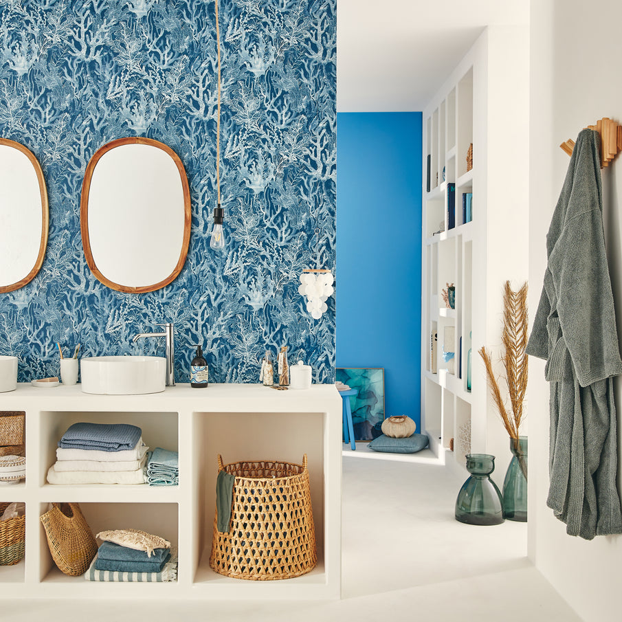 Salle de bain bleue avec vue sur étagère de la chambre adjacente