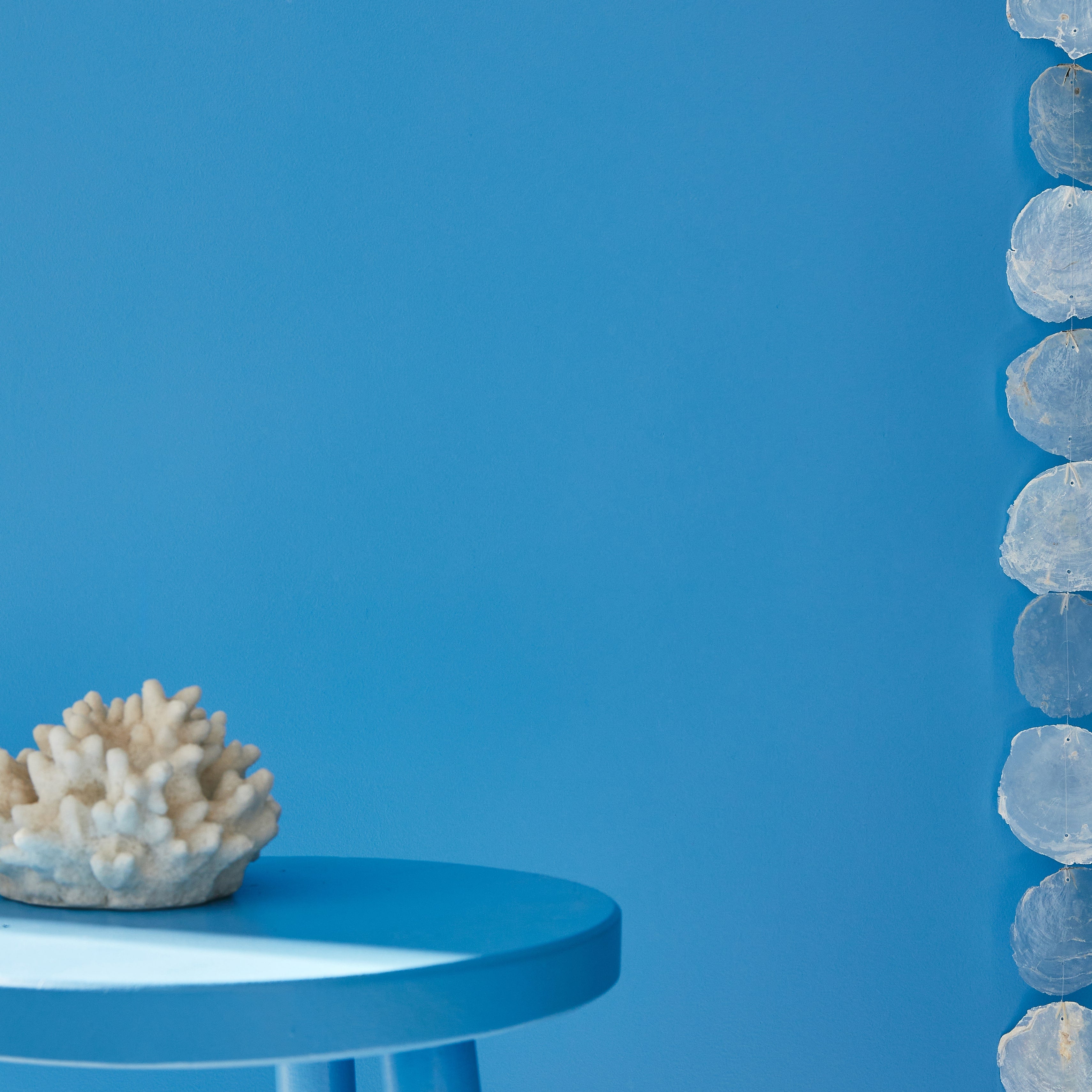 Mur et tabouret peints en bleu médina, style bord de mer