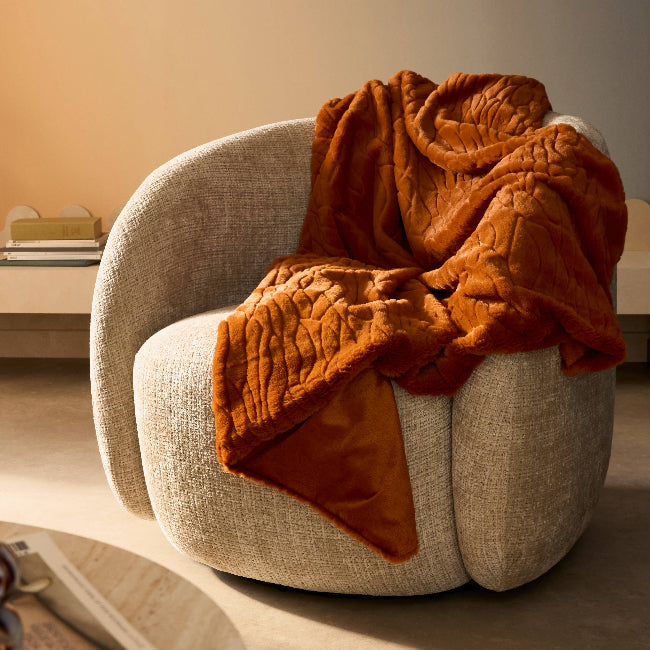 Fauteuil formes arrondies beige, plaid orange fausse fourrure