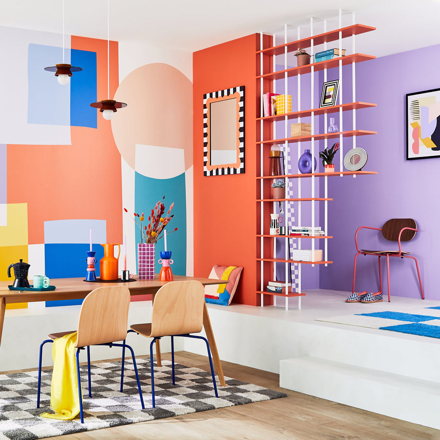 Salle à manger coloré avec papier peint géométrique et déco aux couleurs vives