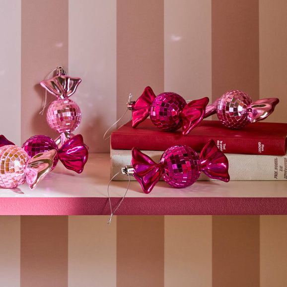 Décoration à suspendre boule à facette en forme de bonbons rose posés sur étagère