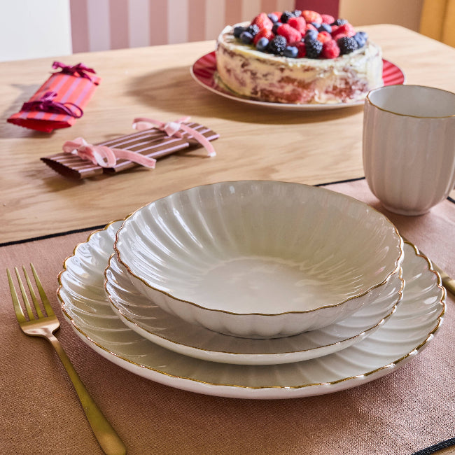 Art de la table, pile d'assiettes blanches au bord doré, table festive