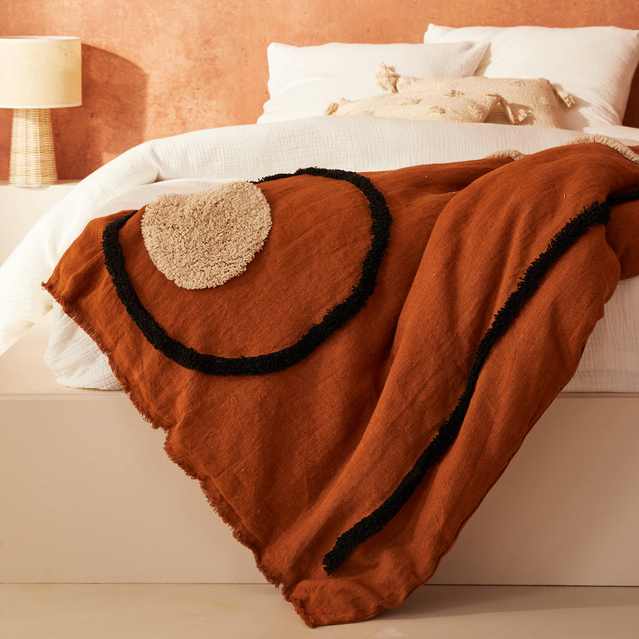 Housse d'édredon couleur caramel avec motif en relief sur lit blanc