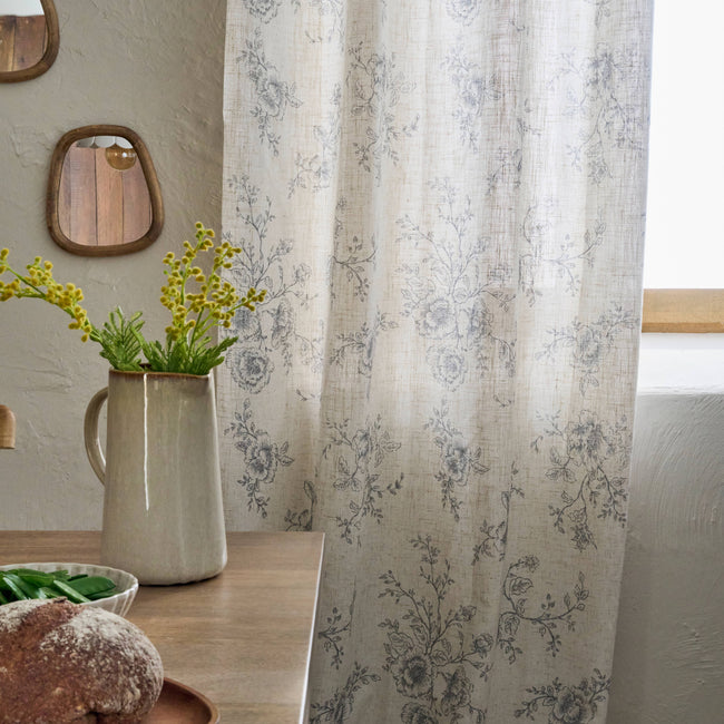 Zoom sur pan de rideau avec motif floral toile de Jouy dans une cuisine nature