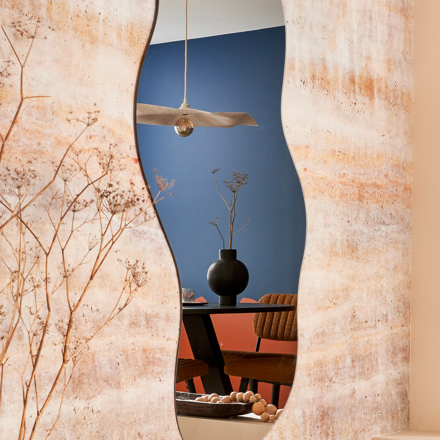 Grand miroir vertical en forme de vague dans un salon style art brut