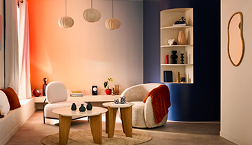 Fauteuils blancs et tables basses, salon couleur bleu nuit, blanc et orangé