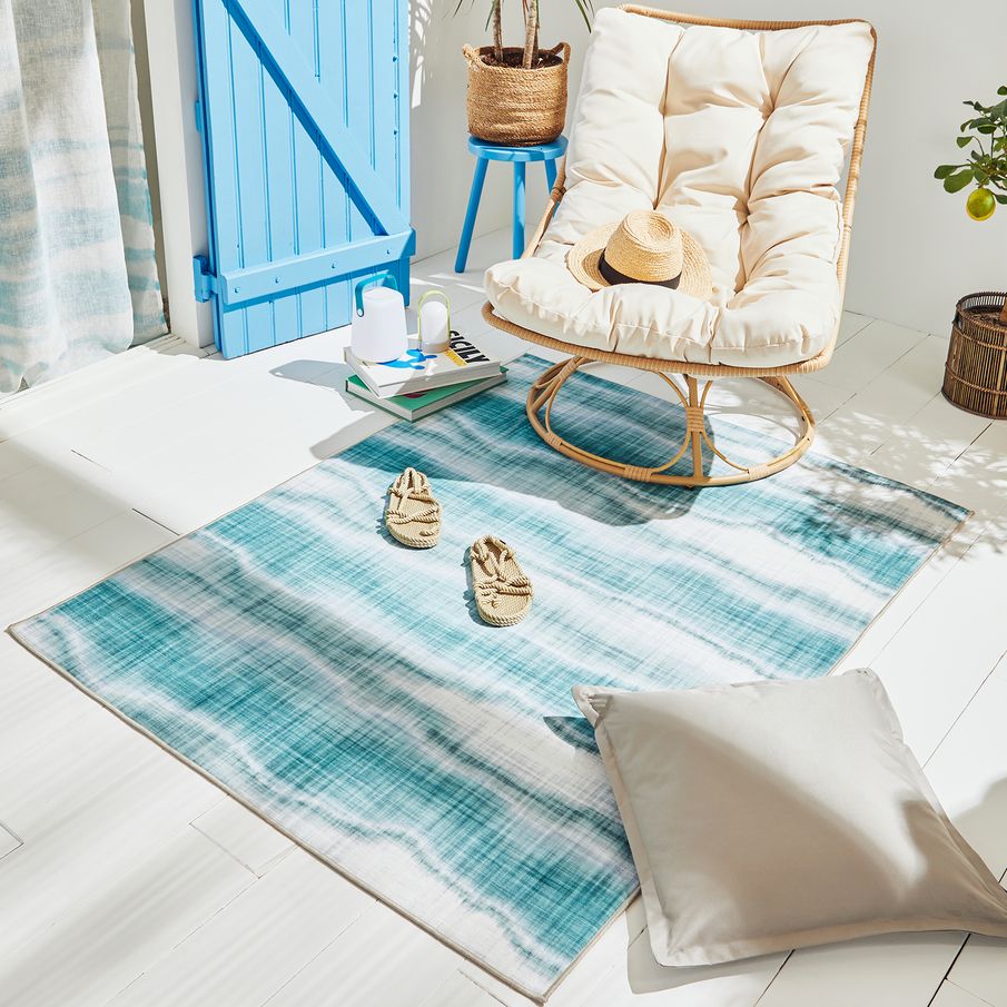 Fauteuil douillet avec tapis et coussins d'extérieur en terrasse