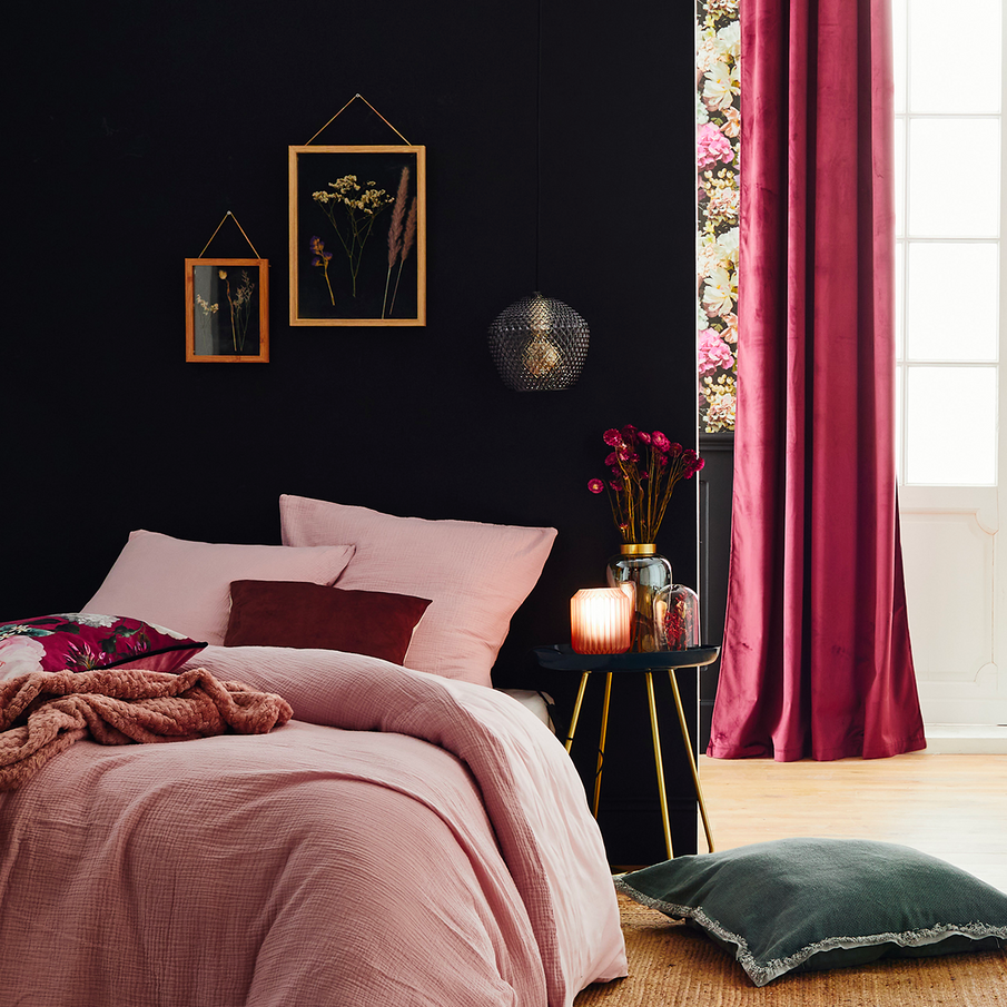 Chambre romantique motif fleuri, lit fait avec parure rose en gaze de coton