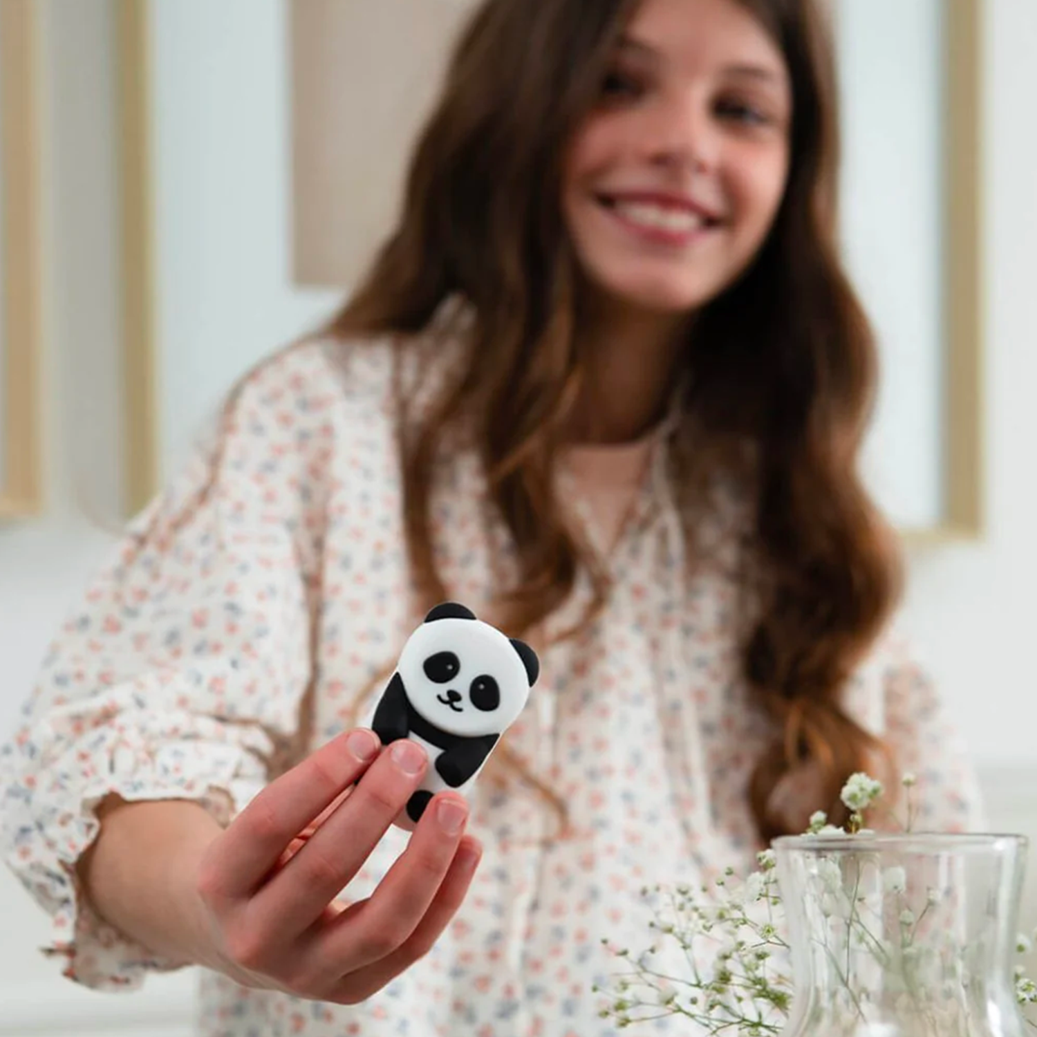 Enfant souriant et tenant un objet connecté Money Walkie en forme de panda