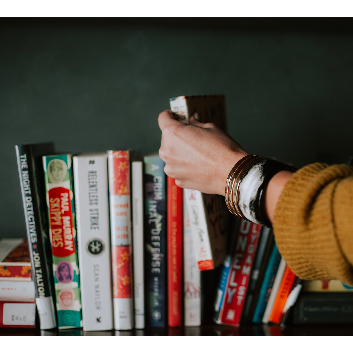 Main retirant un livre d'une étagère à livres