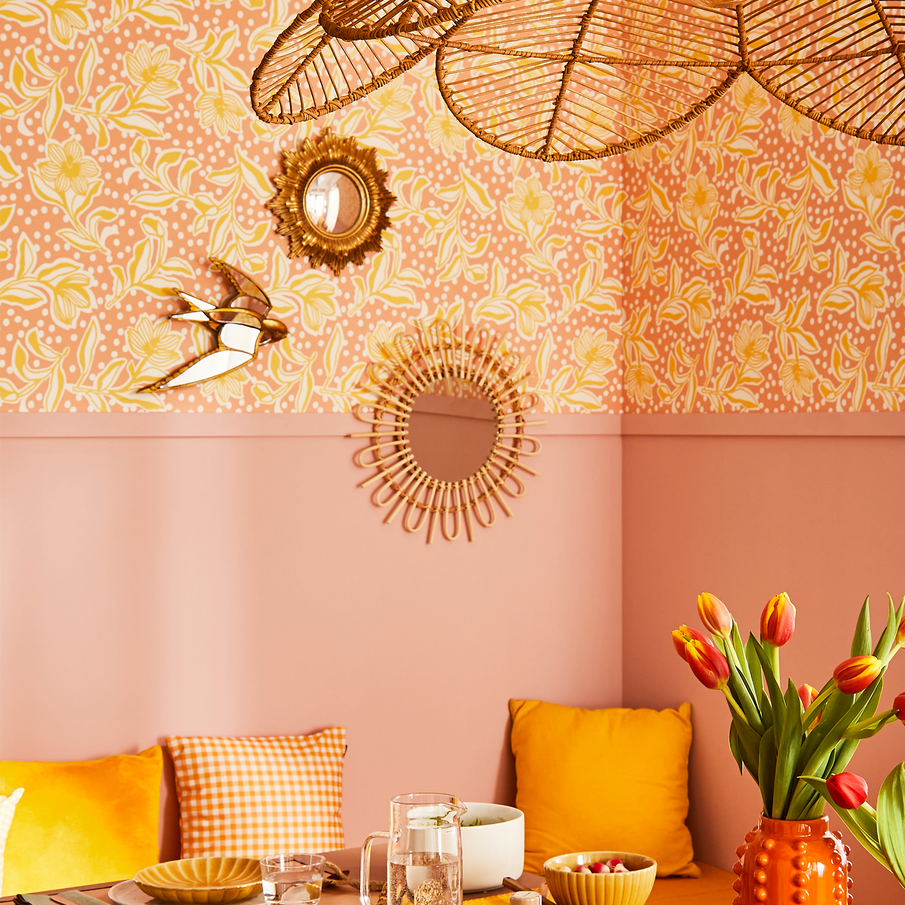 Coin banquette avec un mur rose et papier peint à motif floral rose et abricot 