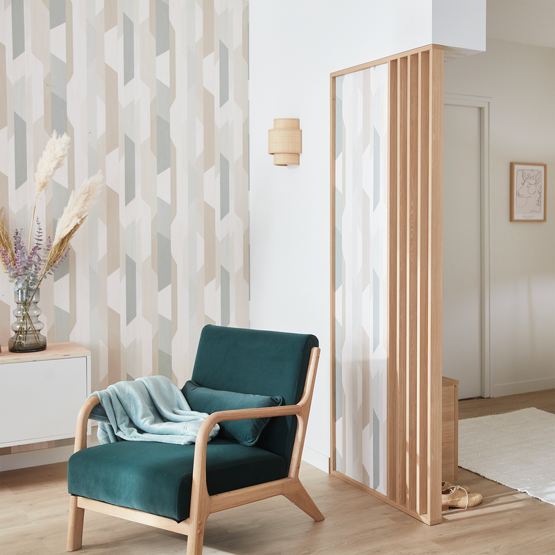 Fauteuil vert dans salon ouvert sur l'entrée délimitée par un meuble de rangement