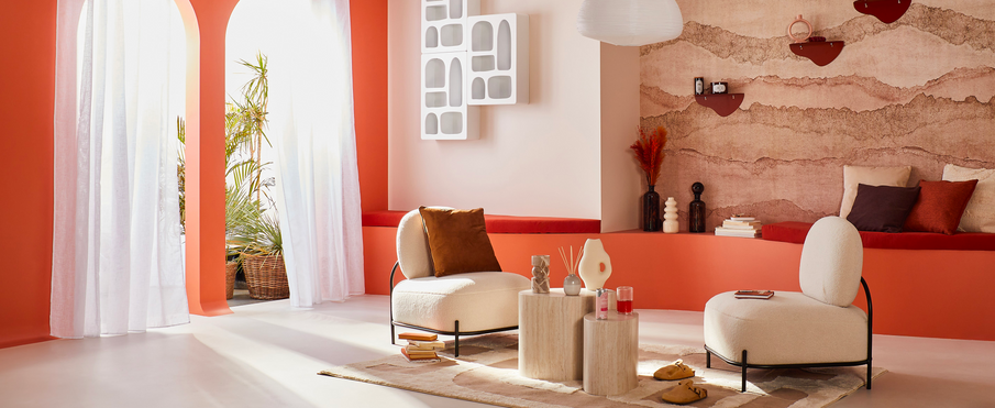 Salon aux tons terracotta et beige avec fauteuils arrondis et déco aux formes organiques