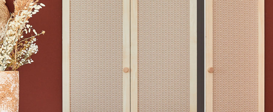 Portes de placard recouverts de papier peint effet cannage à côté d'un mur couleur rouge foncé