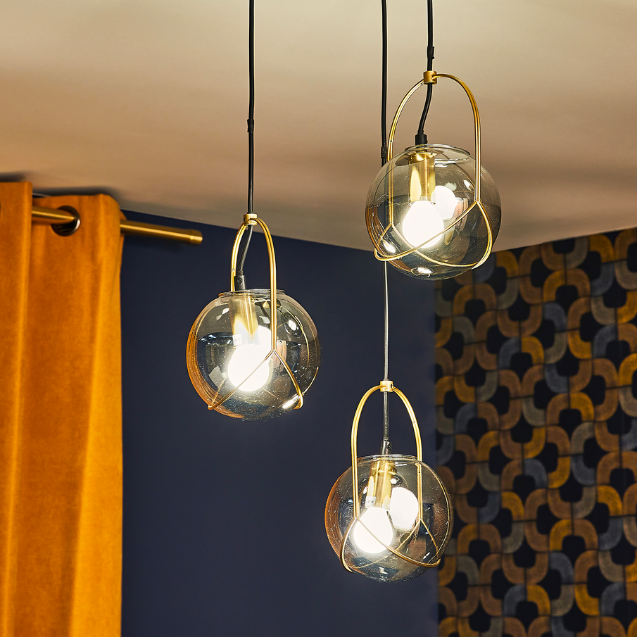 Zoom sur une suspension en trois parties sphériques transparentes et accroches dorées