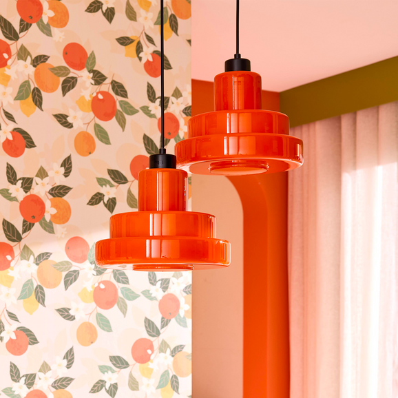 Deux suspensions orange style rétro sur fond papier peint motif agrumes
