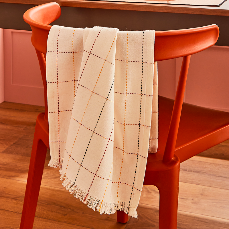 Torchon à rayures suspendu au dossier d'une chaise rouge