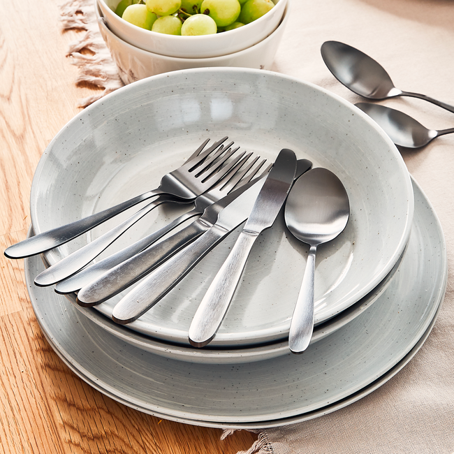 Vaisselle en grés empilée avec couverts