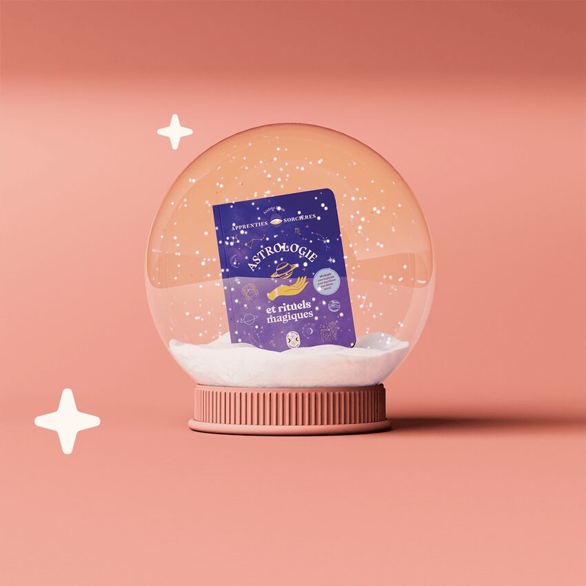 Livre astrologie dans boule à neige fond rose pêche